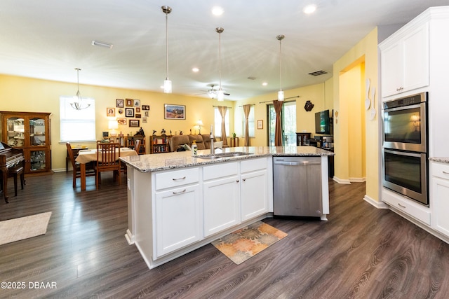 kitchen with visible vents, dark wood-type flooring, open floor plan, stainless steel appliances, and a sink