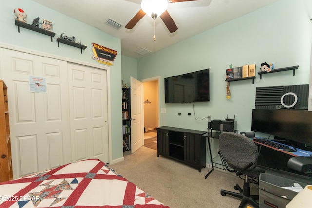 bedroom with visible vents, light colored carpet, a closet, and ceiling fan