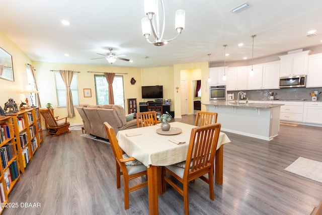 dining area featuring ceiling fan with notable chandelier, recessed lighting, dark wood-style floors, and visible vents