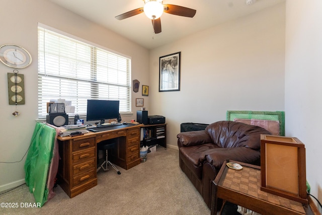 home office featuring light colored carpet, baseboards, and a ceiling fan