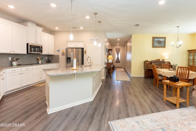 kitchen featuring dark wood finished floors, tasteful backsplash, white cabinetry, and stainless steel appliances