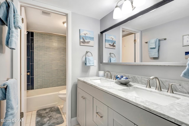 full bathroom with tile patterned floors, toilet, tiled shower / bath combo, and vanity