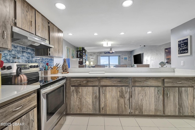 kitchen featuring light tile patterned floors, decorative backsplash, and electric range