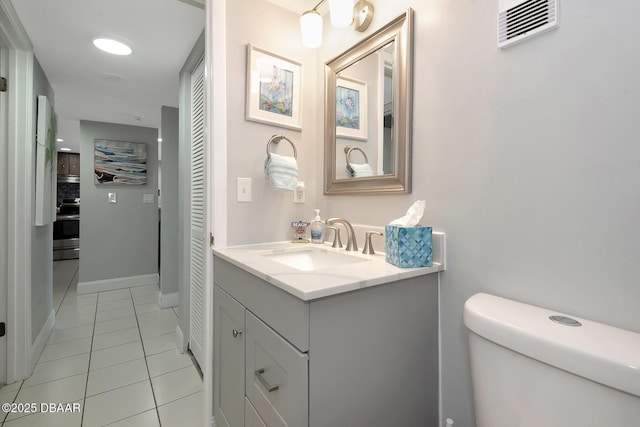 bathroom with vanity, tile patterned floors, and toilet