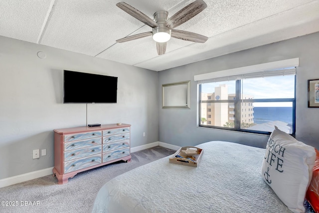 bedroom featuring ceiling fan, carpet, and a textured ceiling