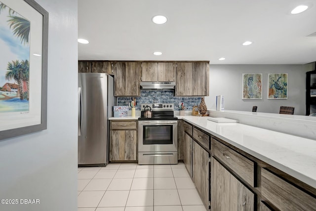 kitchen with light tile patterned floors, backsplash, and stainless steel appliances