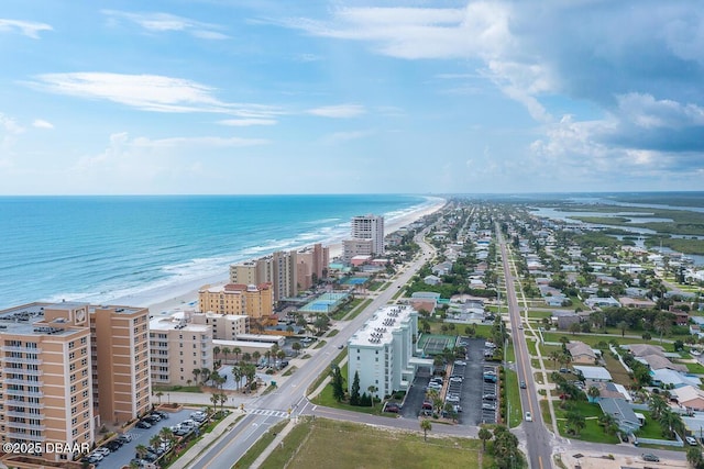 birds eye view of property with a water view and a beach view