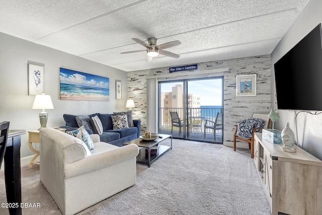 living room featuring light carpet, ceiling fan, and a textured ceiling