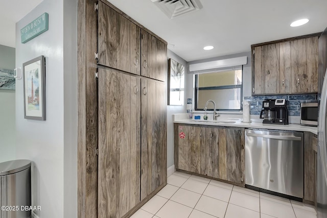 kitchen with tasteful backsplash, sink, light tile patterned floors, and dishwasher