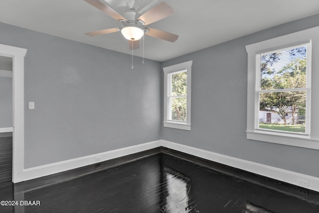 unfurnished room featuring dark wood-type flooring, ceiling fan, and a healthy amount of sunlight