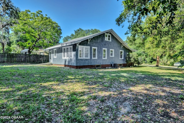 view of side of property featuring central AC unit and a lawn