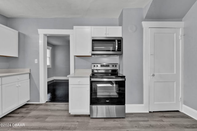 kitchen featuring white cabinetry, light wood-type flooring, and appliances with stainless steel finishes