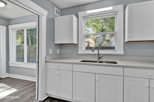 kitchen featuring white cabinetry, hardwood / wood-style floors, and sink