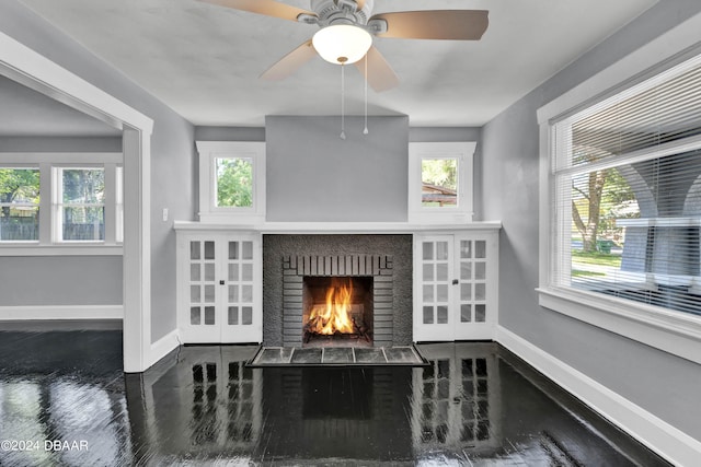 living room featuring a brick fireplace, french doors, a wealth of natural light, and ceiling fan