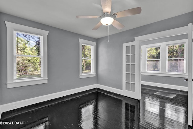 unfurnished room featuring ceiling fan, a wealth of natural light, and wood-type flooring