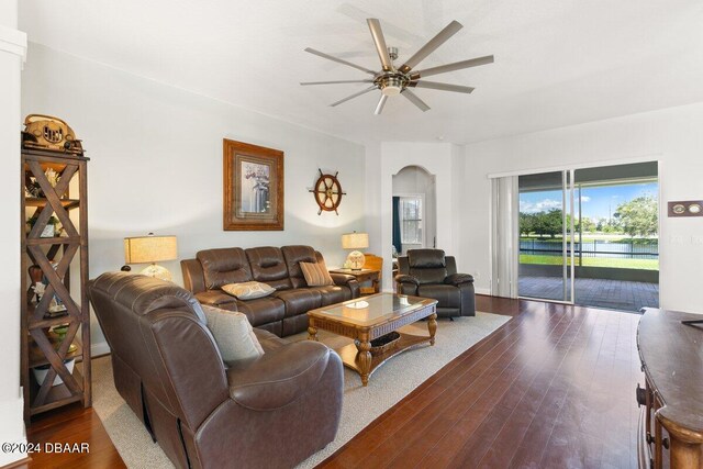 living room featuring ceiling fan and dark hardwood / wood-style floors