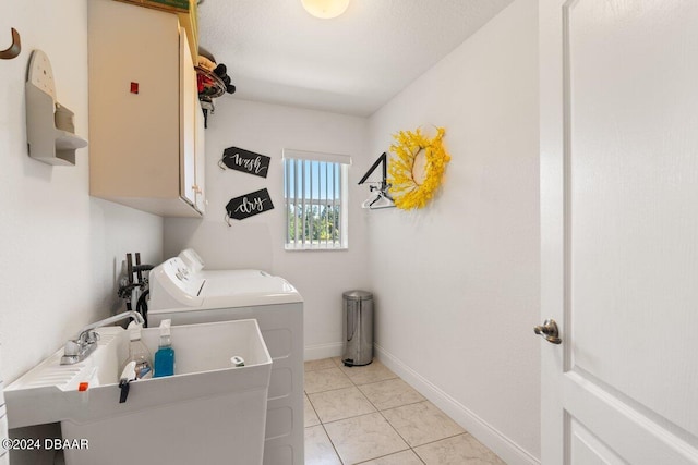 clothes washing area with cabinets, sink, a textured ceiling, light tile patterned floors, and independent washer and dryer