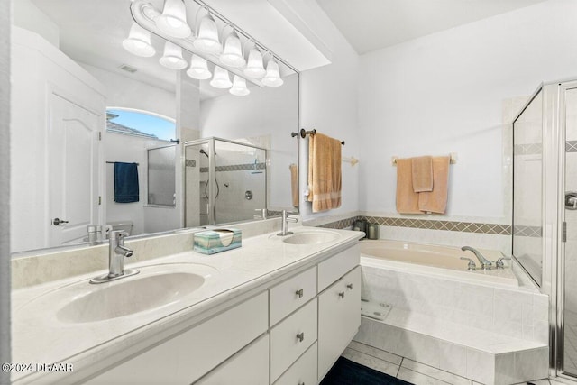 bathroom featuring tile patterned flooring, shower with separate bathtub, and vanity