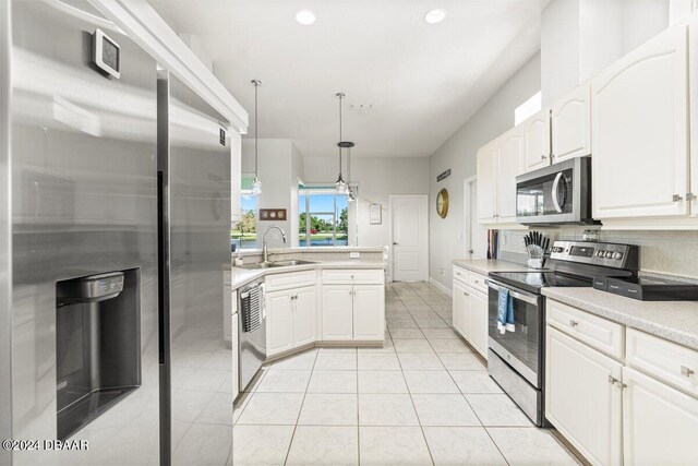 kitchen with stainless steel appliances, light tile patterned floors, hanging light fixtures, sink, and white cabinets