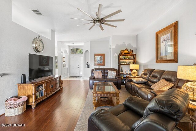 living room featuring dark wood-type flooring and ceiling fan