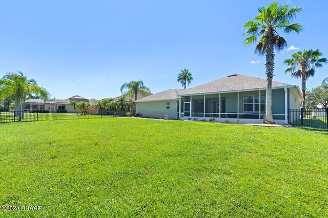 exterior space featuring a sunroom and a lawn