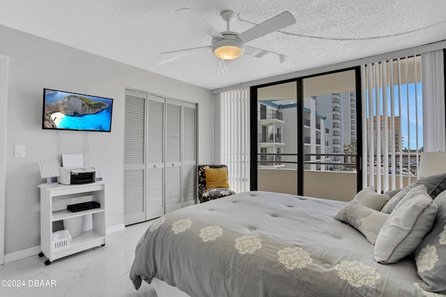 3743 S Atlantic Ave Unit 3D, Daytona Beach Shores, FL 32118 - bedroom with marble finish floors, a closet, baseboards, a ceiling fan, and a textured ceiling