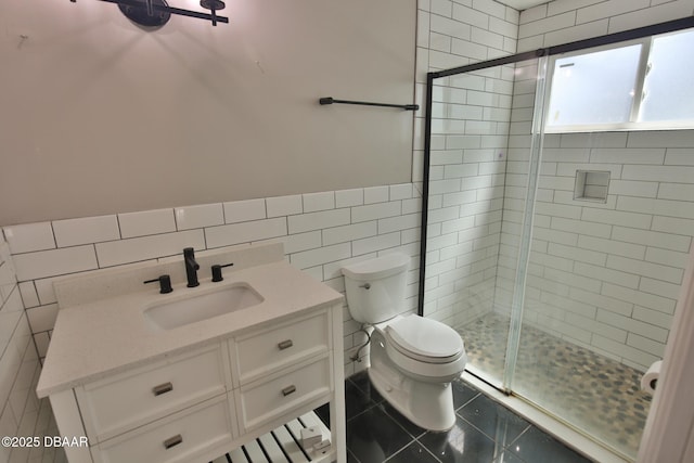 3455 Saddleback Ct, Port Orange, FL 32129 - bathroom with tile walls, toilet, a shower stall, vanity, and wainscoting
