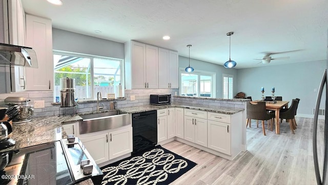 kitchen with pendant lighting, white cabinets, a sink, dishwasher, and a peninsula