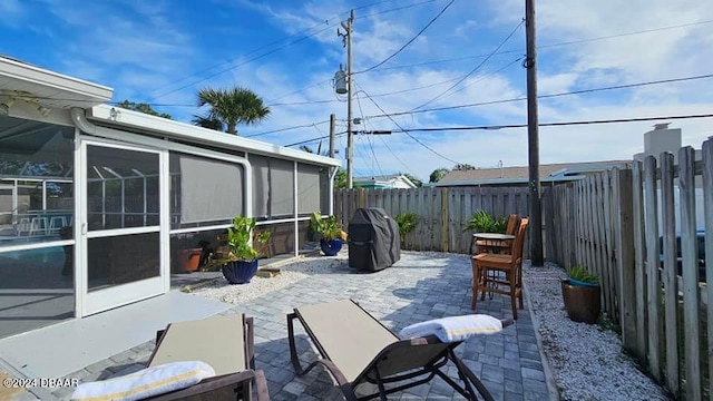 view of patio featuring a sunroom and a fenced backyard