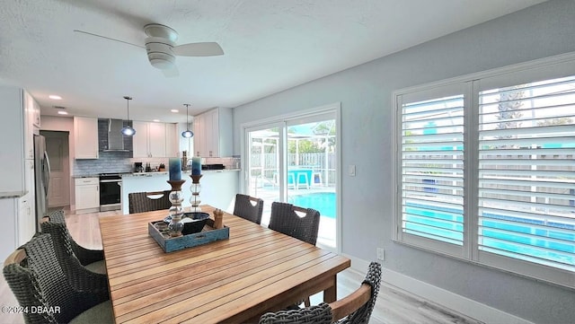 dining area with ceiling fan, light wood finished floors, and baseboards