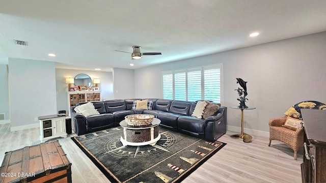 living area featuring visible vents, ceiling fan, baseboards, and wood finished floors