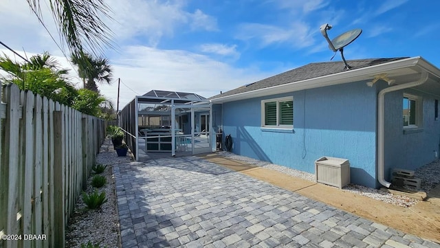 rear view of property with a lanai, a fenced backyard, and a patio