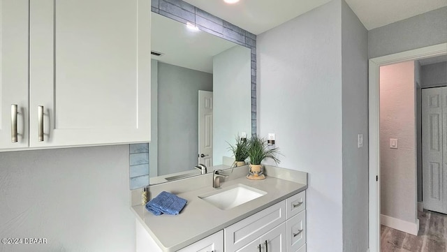 bathroom with vanity, baseboards, and wood finished floors