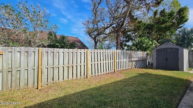 view of yard featuring an outbuilding, a storage unit, and a fenced backyard