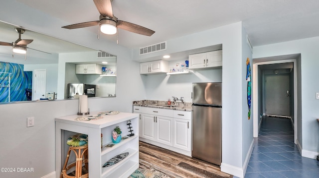 219 S Atlantic Ave Unit 440, Daytona Beach, FL 32118 - kitchen with freestanding refrigerator, open shelves, a ceiling fan, and white cabinets