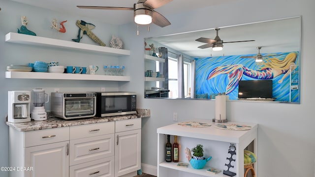 interior space featuring white cabinets and ceiling fan