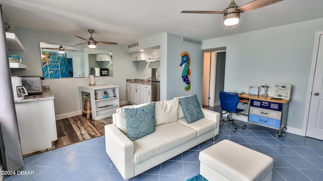 219 S Atlantic Ave Unit 440, Daytona Beach, FL 32118 - living area featuring a ceiling fan, a desk, baseboards, and dark tile patterned floors