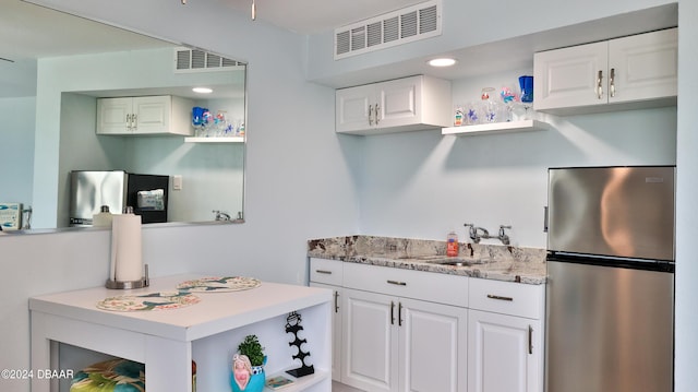 219 S Atlantic Ave Unit 440, Daytona Beach, FL 32118 - kitchen with freestanding refrigerator, open shelves, a sink, white cabinets, and recessed lighting