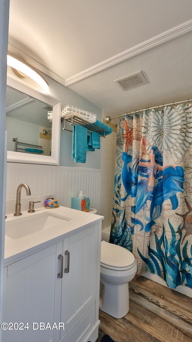 219 S Atlantic Ave Unit 440, Daytona Beach, FL 32118 - full bathroom with wood finished floors, toilet, vanity, shower / bath combo with shower curtain, and a wainscoted wall
