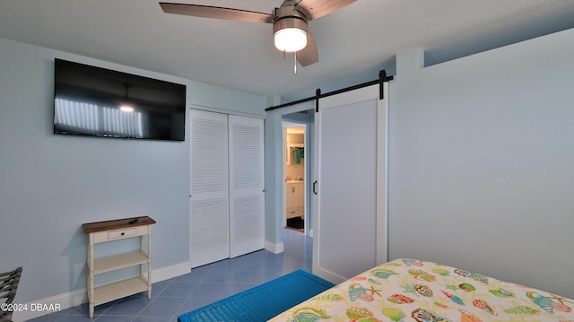 219 S Atlantic Ave Unit 440, Daytona Beach, FL 32118 - tiled bedroom featuring a barn door, a closet, baseboards, and ceiling fan