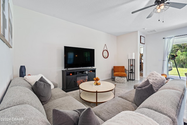 living room featuring a textured ceiling and ceiling fan