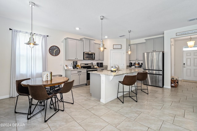1743 Red Rock Rd, New Smyrna Beach, FL 32168 - kitchen with appliances with stainless steel finishes, gray cabinetry, light stone counters, a kitchen breakfast bar, and recessed lighting