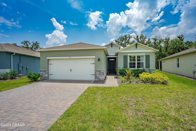 1743 Red Rock Rd, New Smyrna Beach, FL 32168 - single story home featuring decorative driveway, an attached garage, a front yard, stucco siding, and stone siding