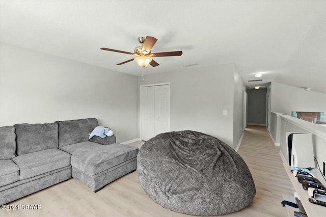 living room with light hardwood / wood-style flooring and ceiling fan