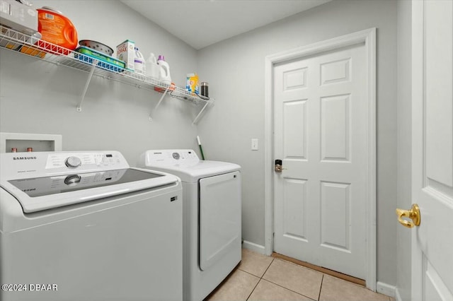 laundry area with separate washer and dryer and light tile patterned floors