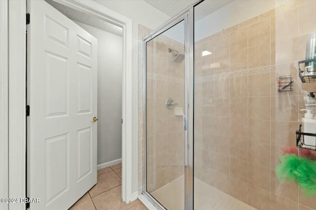 bathroom featuring tile patterned floors, a shower with shower door, and a textured ceiling