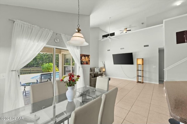 tiled dining room with ceiling fan and high vaulted ceiling