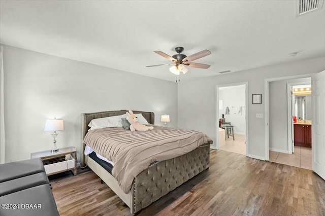 bedroom featuring ceiling fan, dark hardwood / wood-style flooring, and ensuite bathroom