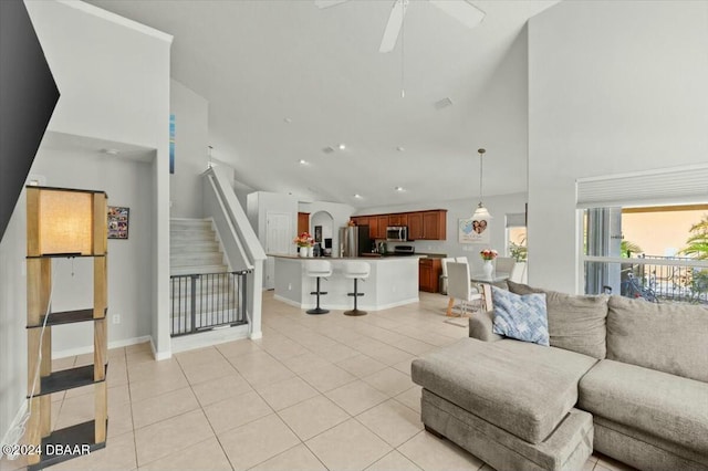 living room featuring ceiling fan, light tile patterned flooring, and high vaulted ceiling