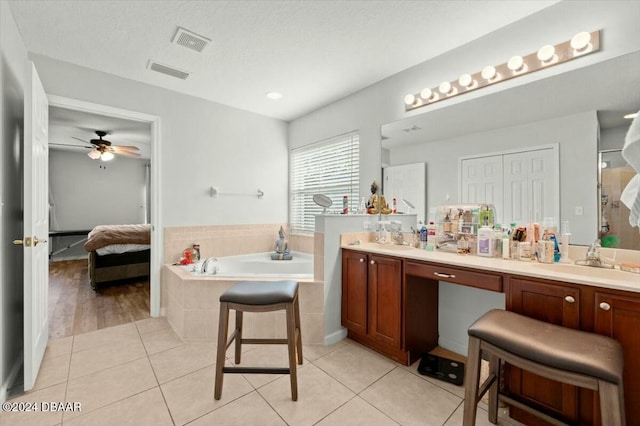 bathroom with tile patterned flooring, vanity, a relaxing tiled tub, and ceiling fan